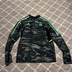 Real Madrid tränings tröja  - Säljer denna feta Real Madrid tränings tröjan!Säljer pga den aldrig kommer till användning. Skick: 9/10 använts få tal gånger. Storlek: M. Den har inga defekter förutom att den är lite nopprig på vissa ställen men inget man märker av. Priset kan sänkas vid snabb affärer 