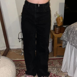 Svarta jeans från Abrand Jeans - Snygga svarta jeans från Abrand Jeans med hög midja och rak passform. De har klassiska femficksdetaljer och en dragkedja med knapp framtill. Perfekta för en stilren look. Defekten som jag lägger märke till är nere vid fötterna där byxorna har slitits av att jag är för kort och byxorna för långa 😅Står ingen st i byxorna men jag har S och dem sitter som en smäck! Jag är 162cm och byxorna är för långa för mig☺️