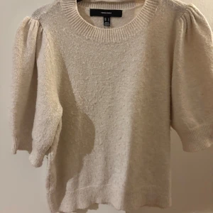 Kortärmad stickad tröja - Säljer en mysig beige tröja från Vero Moda med puffiga trekvartsärmar och ribbad halsringning. Perfekt för en stilren och bekväm look. Passar bra till både jeans och kjol. 🌟Den är lite nopprig