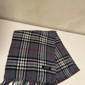 Burberry halsduk - Fin burberry halsduk i bra skick, färgen är en fin grå med rutiga mönster. Passar perfekt till både vinter samt lite kyligare vårdagar.