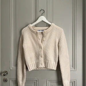 Beige stickad kofta från Zara - Säljer en mysig beige stickad kofta från Zara. Koftan har långa ärmar och knappar framtill. Perfekt för kyliga dagar och ger en stilren look. Passar bra till både jeans och kjol. Liten i storleken❤️
