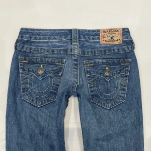 Lågmidjade bootcut jeans från True Religion🤩 - Midja 36 cm rakt över, gren 16 cm o innerben 79 cm💕Jae 169 o xs-s o får inte upp dem över rumpan (därför ser fickorna ut att vara långt ner på sista bilden)