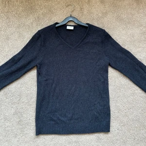Mörkblå stickad tröja - Säljer en V-ringad, mörkblå stickad tröja i strl XS ifrån Vila. Köparen står för frakten🤍