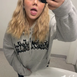 Grå hoodie med tryck - Säljer en grå hoodie med ett coolt tryck i svart på framsidan. Den har en klassisk passform med långa ärmar och en justerbar huva. Perfekt för en avslappnad stil. Inga defekter, köpare betalar för frakt 