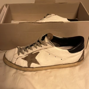 Vita sneakers med stjärndetalj - Säljer ett par vita sneakers från Golden Goose. Riktigt feta till hösten. Rätt så slitna därav priset. Allting og följs med förutom kvitto. Hör av dig om du har en fråga!