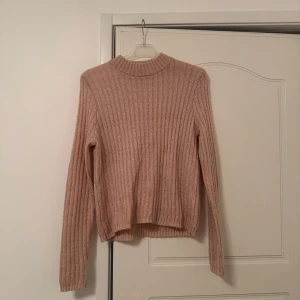 Beige stickad tröja - Säljer en supermysig beige stickad tröja. Den har en ribbad design och långa ärmar, perfekt för kyliga dagar. Tröjan är i nyskick och passar perfekt till både vardag och lite finare tillfällen. Ett måste i garderoben för höst och vinter!