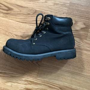 Säljer ett par svarta boots med snörning. De har en robust sula och metallöglor för snörena. Perfekta för höst och vinter, och de ger en cool look till vilken outfit som helst. Lite slitna men fortfarande i bra skick!