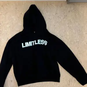 Säljer en svart hoodie med texten 'LIMITLESS' tryckt över bröstet. Den är perfekt för en avslappnad stil och har en klassisk passform med långa ärmar och en bekväm huva. Materialet känns mjukt och skönt, perfekt för kyliga dagar.