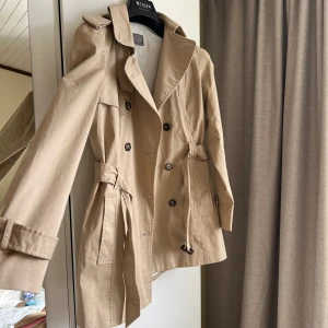 Trenchcoat beige - Klassisk trenchcoat i beige färg. Perfekt i längden. Den är i väldigt bra skick. 