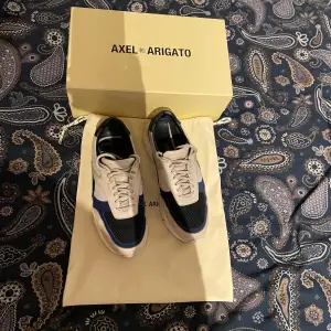 Axel Arigato sneakers i färgerna beige, svart och blå.  Snygga och bekväma skor i bra skick.