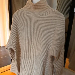 Stickad tröja - Aldrig använd! Väldigt gosig, krämvit stickad tröja! Den sticks inte.