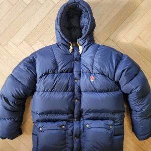 Fjällräven jacka unisex - Jackan har 3 lagningar: - en nedtill på högra ärmen. Är på baksidan så syns inte så mycket.  - ett mindre hål strax på baksida högerärm/axel - ett mindre hål framsida vänster ärm Skriv om i vill se mer😊