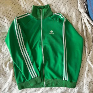 Grön Adidas Tracksuit - Grön tracksuit från adidas. Bra skick men tecken på användning finns. 