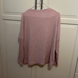 Rosa tröja från H&M - Mysig rosa tröja från H&M i storlek M. Perfekt för kyliga dagar med sin mjuka och bekväma passform. Tröjan har långa ärmar och en enkel design som gör den lätt att matcha med olika outfits. 