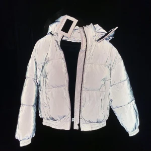 Reflex Jacka  - Grå vinterjacka med reflektiv utsida. Den är varm och skyddar från vind (windbreaker material). Bra om man är ute mycket på kvällen, men fin under dagen då reflexen inte syns! 