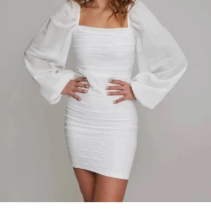 Vit klänning med puffärmar - Säljer en superfin vit klänning med puffiga långärmar och en tight passform. Perfekt för sommarens fester eller en elegant midsommarlook. Klänningen har en stilren design med en fyrkantig urringning och är gjord i ett lätt och bekvämt material.