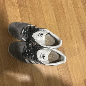 Gråa adidas gazelles  - Säljer nu ett par gråa gazelles i storlek 40 som jag fick av en vän då de inte används de är äkta och det finns inga defekter. Väldigt fina och fräscha skor med den överligt snygga färgen. Har själv ett annat par likadana och dom är otroligt sköna. Dom här är både för er tjejer eller er killar med storleken 40-41 de var köpta för ungefär 1.2 på boozt. Pris går att diskuteras