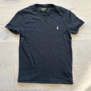 Svart t-shirt från Polo Ralph Lauren - Säljer en svart t-shirt från Polo Ralph Lauren i storlek S. Perfekt för en casual look eller att ha under en skjorta. T-shirten är i bra skick och gjord av mjuk bomull.