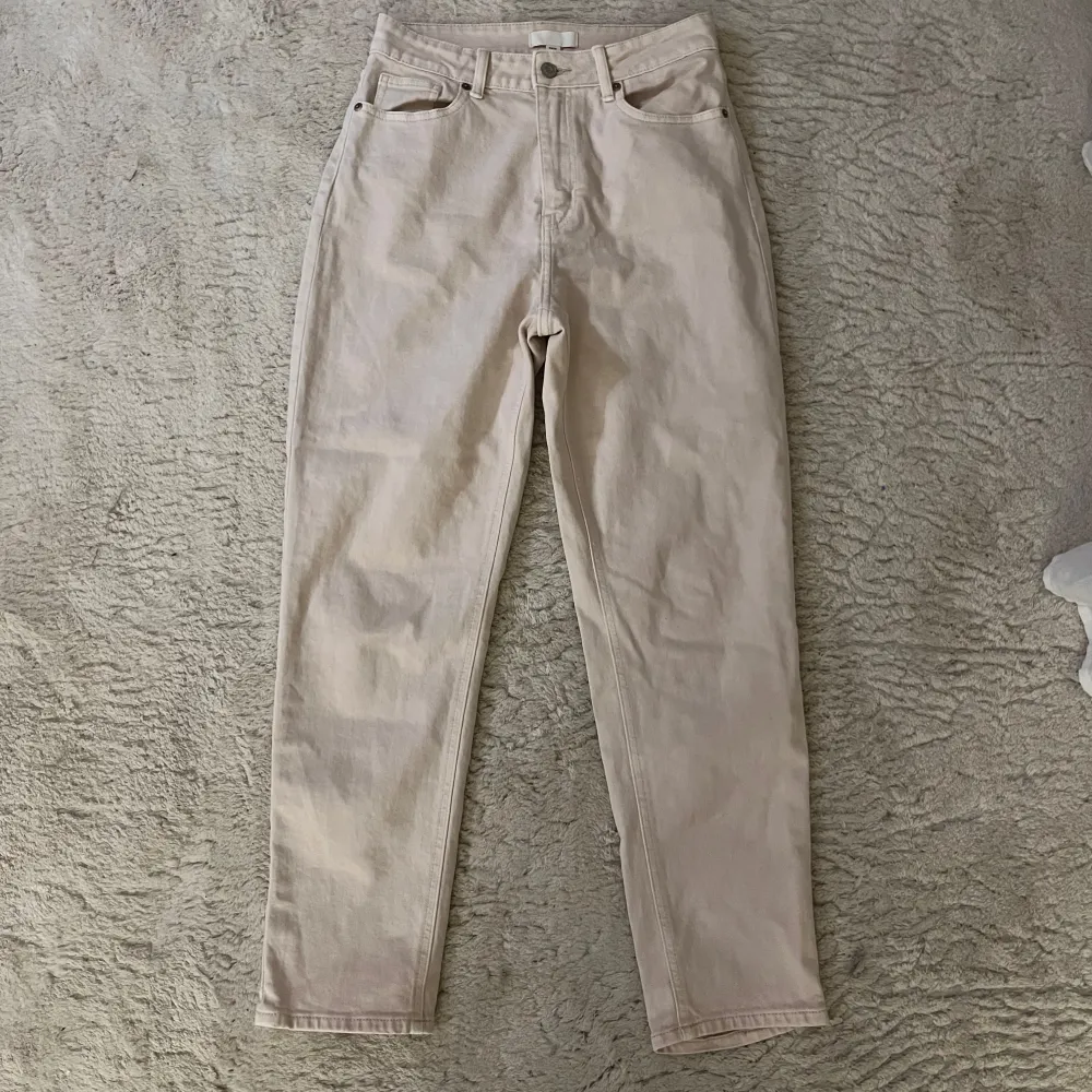 Säljer ett par snygga beige jeans från H&M i storlek 38. De är högmidjade med en straight passform och klassisk femficksdesign. Perfekta för både vardag och fest! 🥳. Jeans & Byxor.