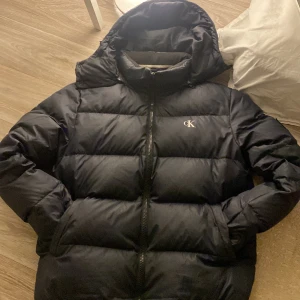Vinterjacka - Skön vinterjacka. Använd fåtal gånger men har en liten grej i bak. Finns på bild. Dragkedja finns till luvan. Nypris 1400 kr
