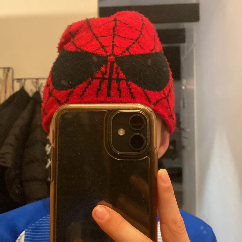 Cool röd mössa med svart spindelmotiv och nätmönster. Perfekt för att hålla sig varm och stilren under kalla dagar. Passar både för vardag och speciella tillfällen. 🕷️. Accessoarer.