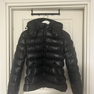 Moncler puffer jacket figursydd  - Jag säljer en snygg, trendig och varm jacka nu till vintern från moncler. Jackan är i väldigt bra skick, inga skador eller märken trots många års användning. Snygg och universell till både vardags men även till lite finare tillfällen, och går ihop med alla typer av stilar. För diskussion om pris visas även köpintyg från Nordiska Kompaniet!
