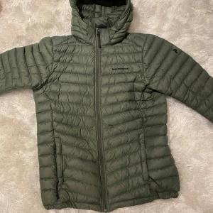 Grön jacka från Peak Performance - Säljer en grön jacka från Peak Performance. Perfekt för höst och vinter. Jackan har några fläckar men är annars i bra skick. Har inte testat att tvätta jackan så fläckarna kanske går bort. Passar för både vardag och utomhusaktiviteter.