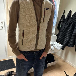 Beige fleeceväst från Patagonia - Säljer en fleeceväst från Patagonia i storlek S. Perfekt för höst och vår! Den är bra skick 8/10. Västen är för liten för modellen då han bär M och L.