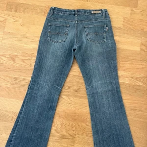 Blå bootcut jeans - Säljer ett par snygga blå bootcut jeans i bra skick. Köpte second hand men tyvärr för små för mig, passar nog en xs. Så fina verkligen och jättenajs passform!