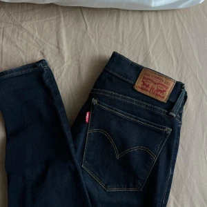 Mörkblå jeans från Levi's - Säljer ett par snygga mörkblå Levi's jeans i storlek 26. De har en klassisk design med fem fickor och en dragkedja med knapp. Perfekta för både vardag och fest! 🖤