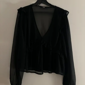 Svart blus - En superfin svart blus. Långärmad och v ringad. Den är använd fåtal gånger och är i mycket bra skick!