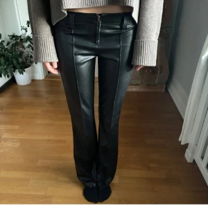 Svarta skinnbyxor med dragkedja - Snygga svarta skinnbyxor i mycket bra skick. De är lågmidjade och har en dragkedja framtill. Byxorna har en straight passform. Perfekta för höst och vinter!🤩🤩🤩