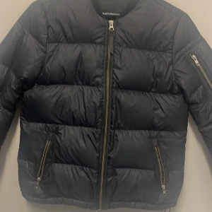 Svart dunjacka från Peak Performance - Säljer en snygg svart dunjacka från Peak Performance. Jackan har en dragkedja framtill och praktiska fickor med dragkedjor. Perfekt för kyliga dagar och har en stilren design. Passar både till vardags och lite finare tillfällen. 🖤