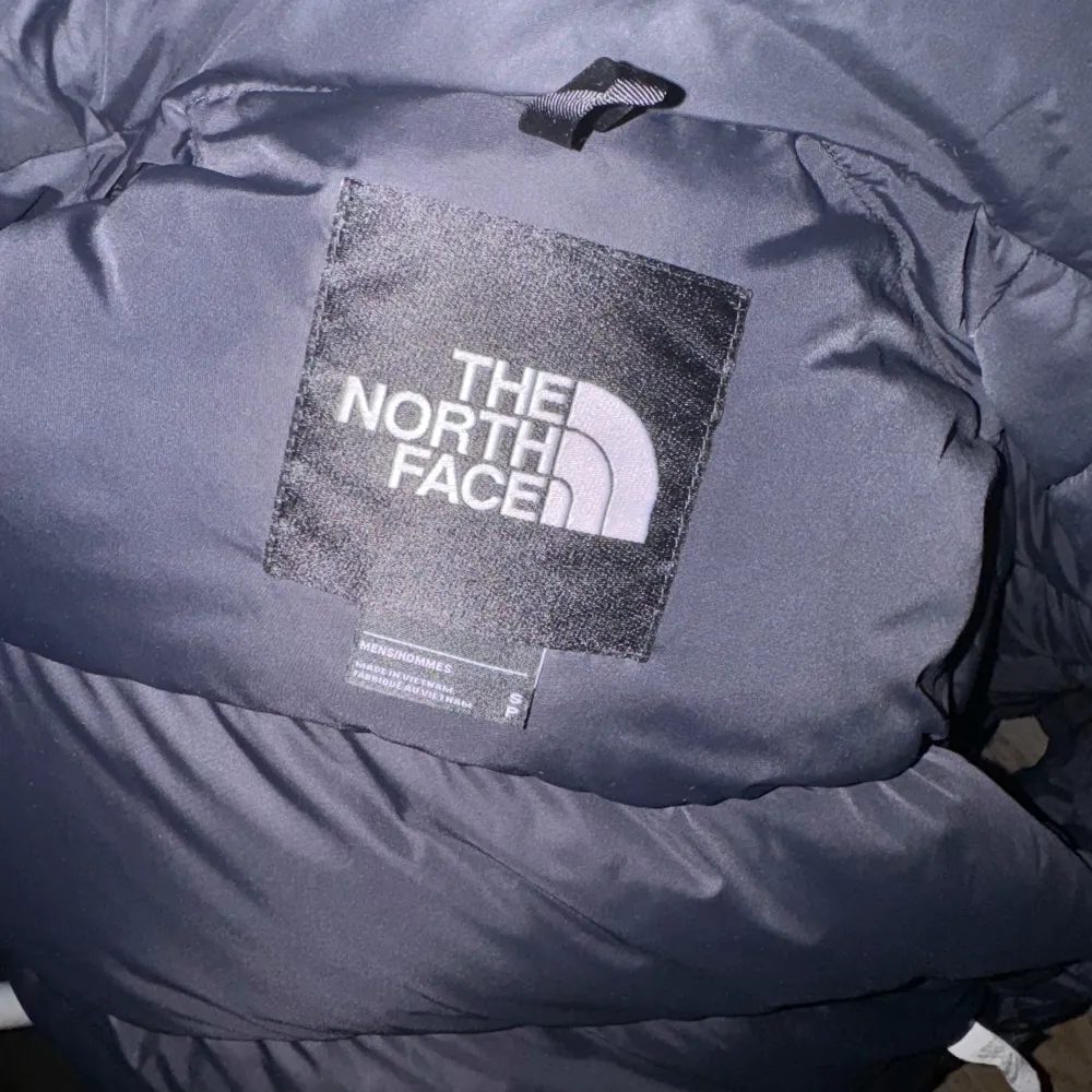 Säljer en svart pufferjacka från The North Face. Modellen är -176- cm och väger 68kg. Jackan har en dragkedja och är perfekt för kalla vinterdagar. Den är i bra skick men har ett litet hål på baksidan som man ej ser. Stor logga på bröstet och ryggen. Perfekt för dig som vill hålla dig varm och stilren! Pris kan diskuteras vid snabb affär . Jackor.