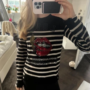 Randig tröja från Zadig & Voltaire - Säljer en supercool randig tröja från Zadig & Voltaire i svart och vit. Den har ett stort, glittrigt läppmotiv på framsidan! Tröjan är i kashmir och har långa ärmar, perfekt för höst och vinter! Använd ett fåtal gånger men är helt i nyskick! Priset är diskuterbart vid snabb affär 😇❤️