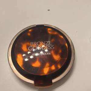 Säljer en snygg bronzer från Estée Lauder i nyansen 02 Medium. Den kommer i en lyxig förpackning med ett mönster som påminner om sköldpaddsskal. Perfekt för att ge ansiktet en solkysst look året runt. Produkten väger 21g och är lätt att applicera för en naturlig glöd.