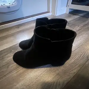 Säljer ett par snygga svarta boots i mocka. De har en låg klack och dragkedja på sidan för enkel på- och avtagning. Perfekta för höst och vinter, och passar både till vardags och fest. De är i mycket bra skick och redo för nya äventyr! Bra skick därav priset