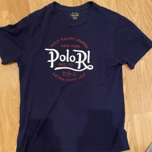 Ralph Lauren - Säljer en snygg mörkblå t-shirt från Polo Ralph Lauren med tryck! | Passform S/M | Skick 8/10 | Lite av trycket har släppt se bild (2) | bara höra av sig vid frågor🙌