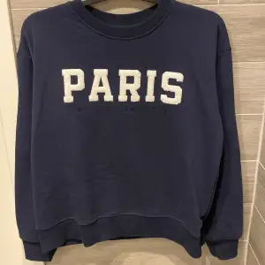 Säljer en snygg mörkblå sweatshirt med stort 'PARIS' tryck på framsidan. Perfekt nu för hösten, använt en gång💗