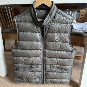 Moncler gui väst  - Sjukt snygg moncler gui väst i storlek 2. Galet bra skick, en söm som gått upp lite i högra hörnet. 