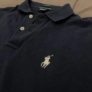 Ralph Lauren piké  - Snygg Ralph Lauren piké. Köpt på second hand och jag tror det är en äldre modell pga annorlunda neck tag. Den är i bra skick och har inga defekter. Jag på bilderna är 185 och väger runt 70kg.  Kontakta mig för fler bilder eller frågor 😁 