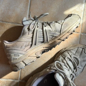 Asics Gel ahar - Sparsamt använda. Förutom att de ser lite smutsiga ut är de i väldigt fint skick, inget slitage, inte ingångna.  Bara använda ett fåtal gånger eftersom storleken inte känns helt rätt för mig. Fin krämig vit färg med ljuslila detaljer.