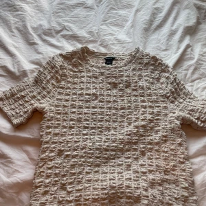 Beige t-shirt - Beige t-shirt med ett fint rutigt mönster, från Lindex, storlek M