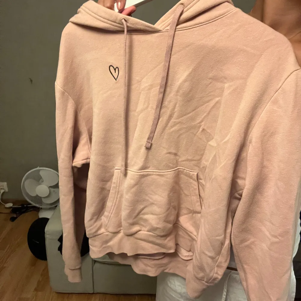 Rosa hoodie från H&M i storlek S med ett litet svart hjärta på bröstet 🤍. Hoodies.