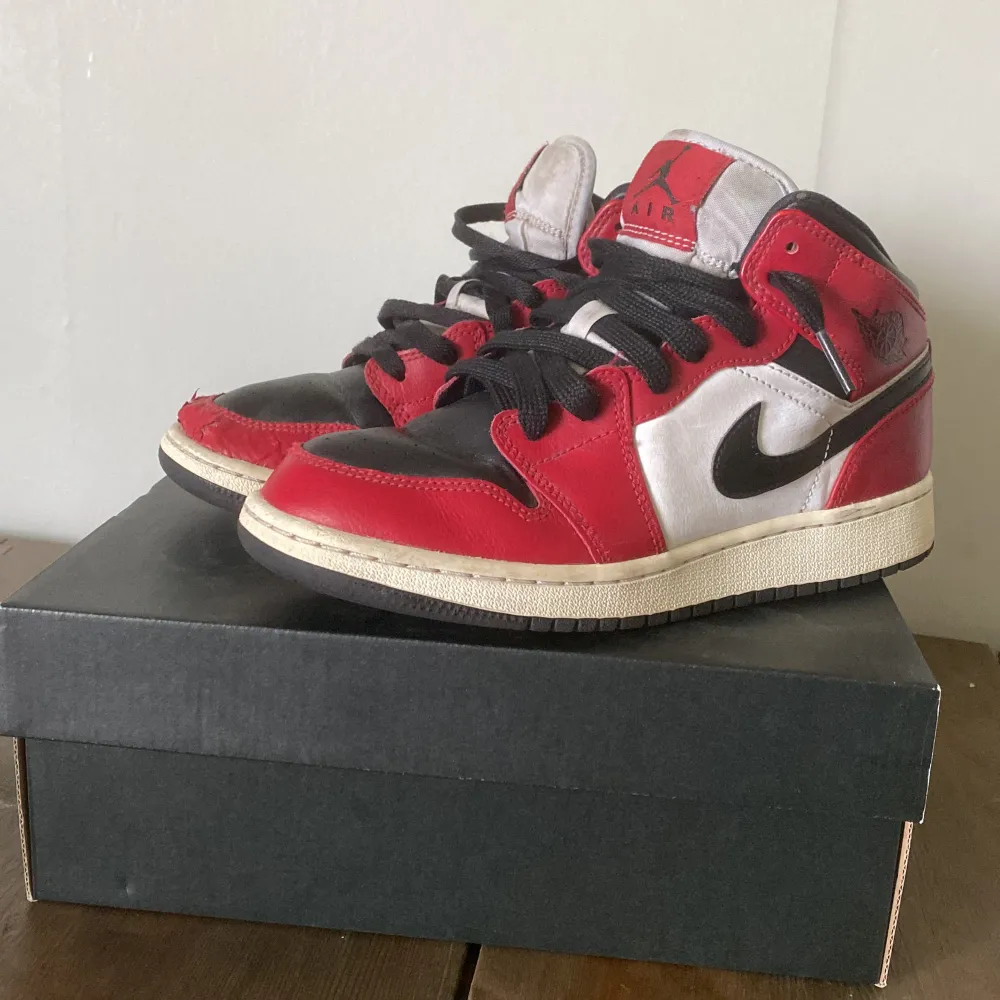 Säljer ett par Jordan 1 mid för dom är för små. Fint skick förutom att det är lite förstört på högra skon där fram, syns på bild. Pris kan diskuteras, orginal pris 3000SEK💵. Lådan följer med. . Kengät.