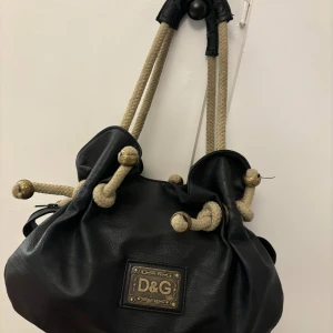 Vintage dolce & Gabbana väska - Vintage dolce Gabbana väska  Har såklart åldrats lite men annars fint skick  Kom med bud ifall priset inte faller i din smak
