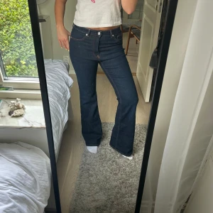 Mörkblå jeans - Bootcut Jeans i twill mörkblå jeans med guld trådar midjemått: 82 cm innerbenslängd: 77 cm