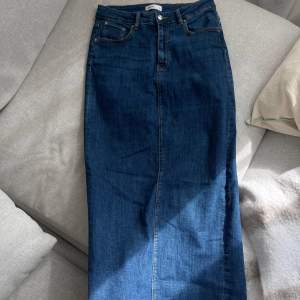 En blå stretchiga denimkjol med mid waist och slit där bak. Storlek 38. Använd flertalet gånger, kan ha någon liten fläck men tvättas såklart innan försäljning!   Köparen står för frakten och varan går ej att returnera💙