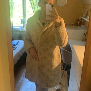 Beige pälsjacka från MyWear - Säljer en supermysig beige pälsjacka från MyWear. Den är perfekt för kyliga dagar och har en mjuk och fluffig känsla. Jackan har en klassisk stil som passar till det mesta. Perfekt för höst och vinter! ❄️ 