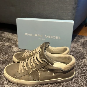 Phillipe Model Skor - Ett par grå Phillipe Model skor i användt skick men ändå fina. Färg grå, storlek 41, köpta nya. Inte tvättade i bilden, pris går att diskuteras.
